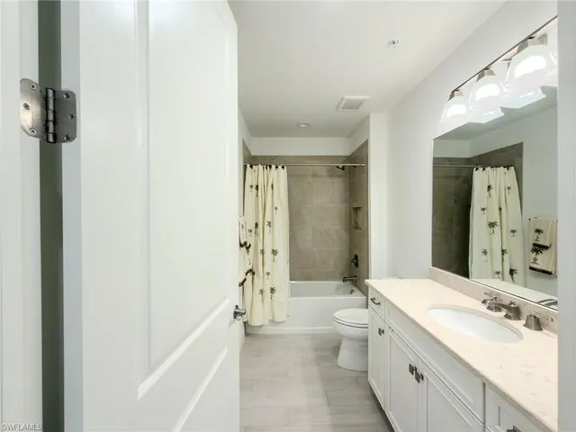 a bathroom with a double vanity sink toilet mirror and shower