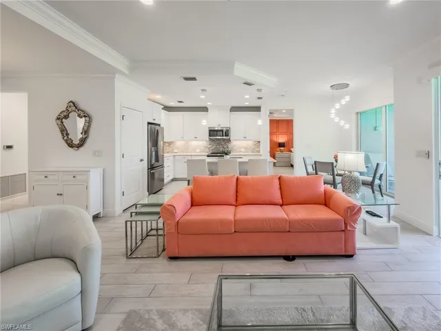 a living room with furniture a rug and kitchen view