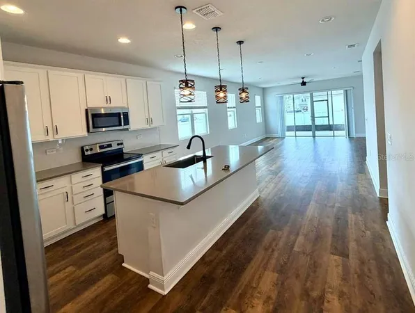 a kitchen with kitchen island white cabinets and stainless steel appliances