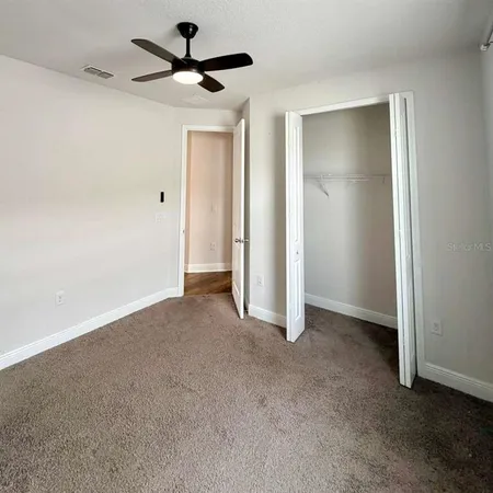 a view of an empty room and a ceiling fan