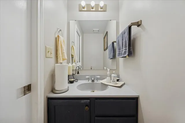 a bathroom with a sink vanity and a mirror