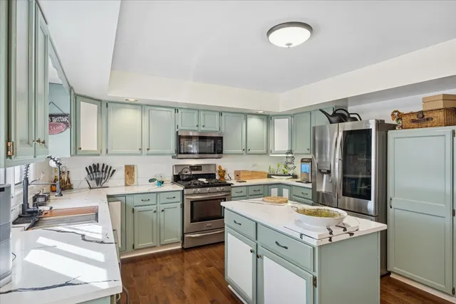 a kitchen with stainless steel appliances a stove refrigerator sink and microwave