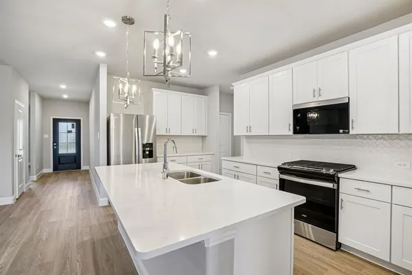 a kitchen with a sink a stove and cabinets
