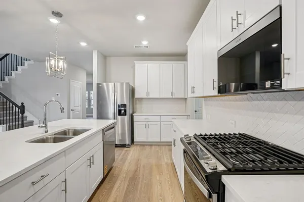 a kitchen with a sink stainless steel appliances and cabinets