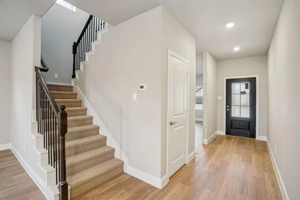 a view of a hallway with wooden floor and entryway