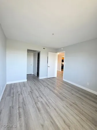 a view of empty room with wooden floor