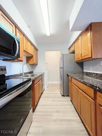 a kitchen with stainless steel appliances granite countertop a stove a sink and a microwave