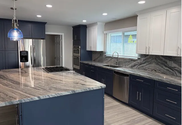 a kitchen with granite countertop kitchen island stainless steel appliances a sink stove and refrigerator