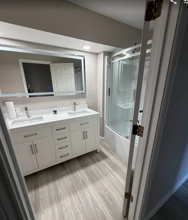 a bathroom with a double vanity sink mirror double and shower
