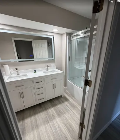 a bathroom with a double vanity sink mirror double and shower