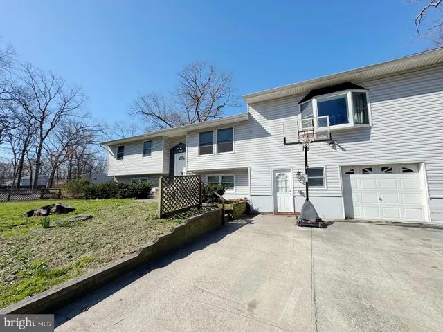 a view of a house with backyard and trees