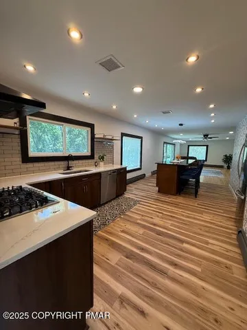 a large kitchen with stainless steel appliances a large counter top