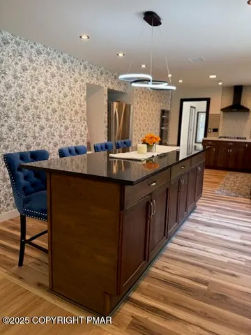a kitchen with kitchen island a sink stove and wooden floor