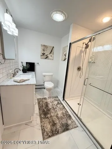 a bathroom with a sink a toilet and shower