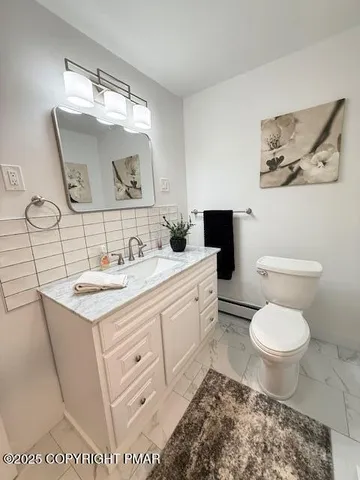 a bathroom with a toilet sink and mirror