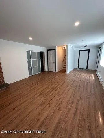 a big room with wooden floor and windows