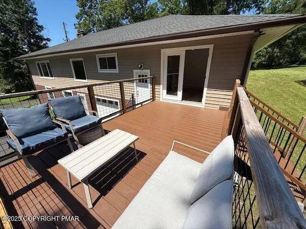a view of a patio with table and chairs with wooden floor and fence