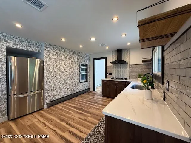 a kitchen with stainless steel appliances kitchen island granite countertop a refrigerator and a sink