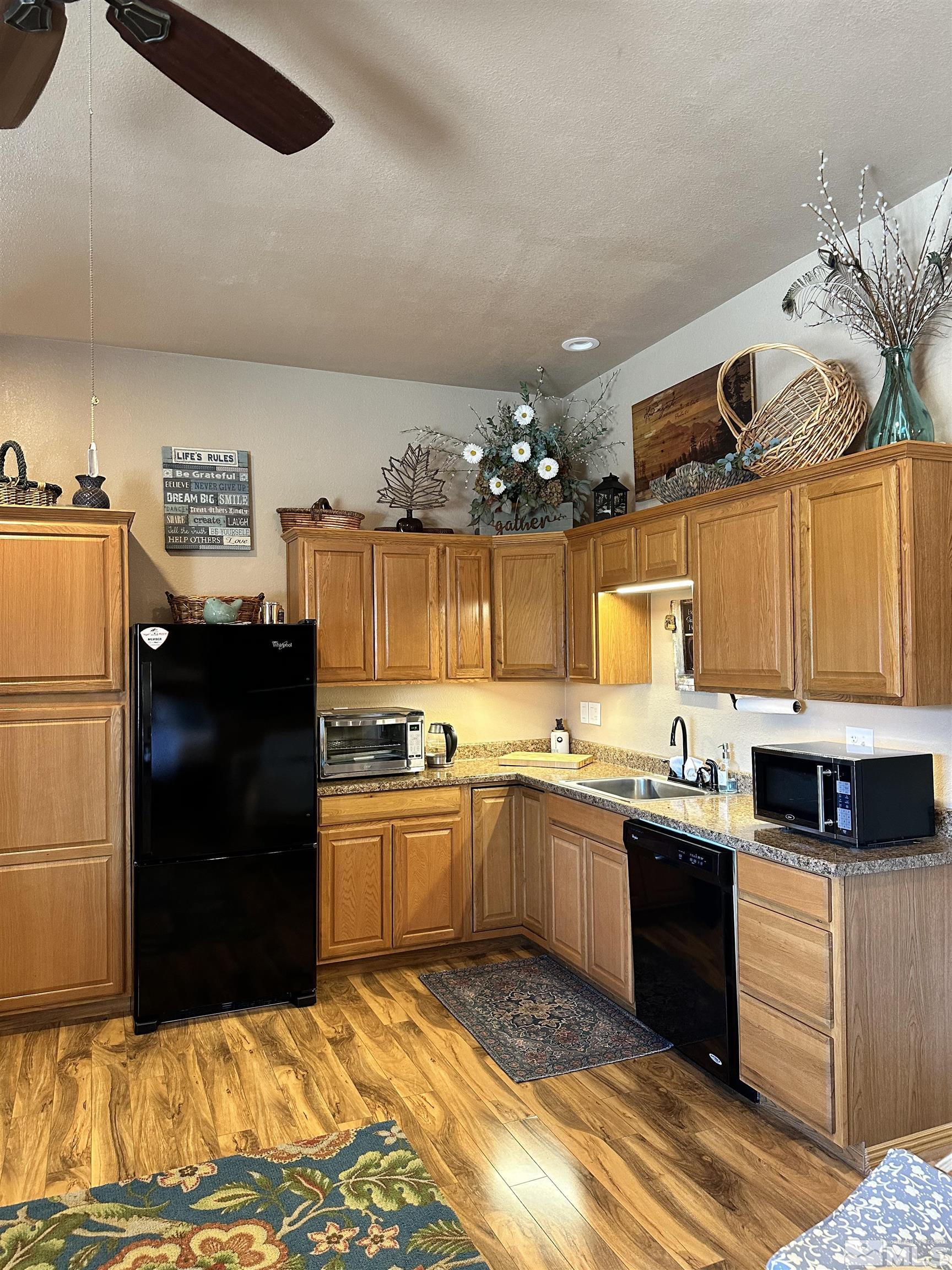 580 Silver Circle Tonopah, NV 89049 - Photo 19 of 37 a kitchen with granite countertop a sink and a refrigerator