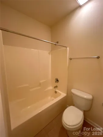 a white toilet and tub sitting next to a bathroom sink