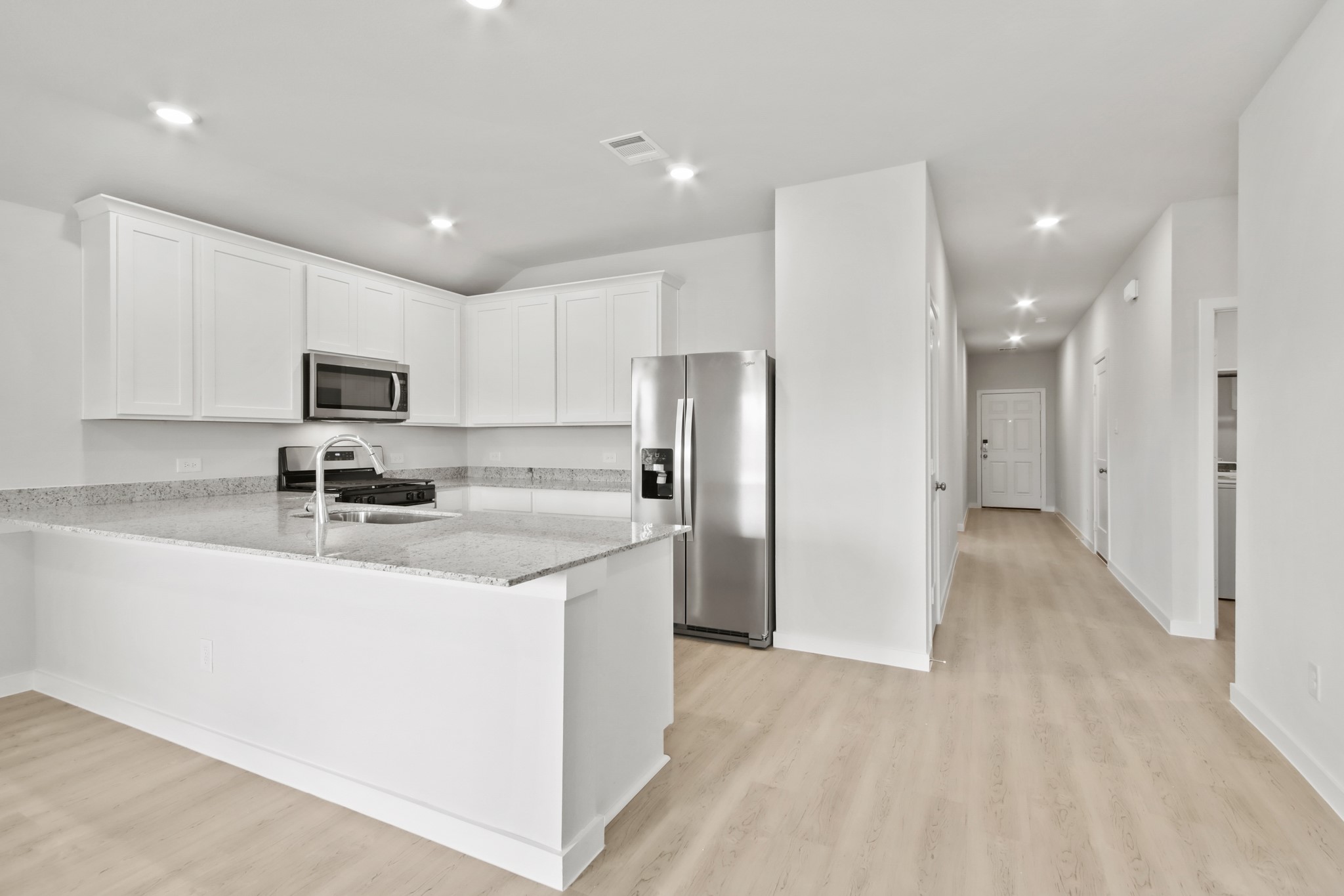 9715 Caney Bend Road Conroe, TX 77303 - Photo 3 of 24 a kitchen with a refrigerator a sink and a microwave