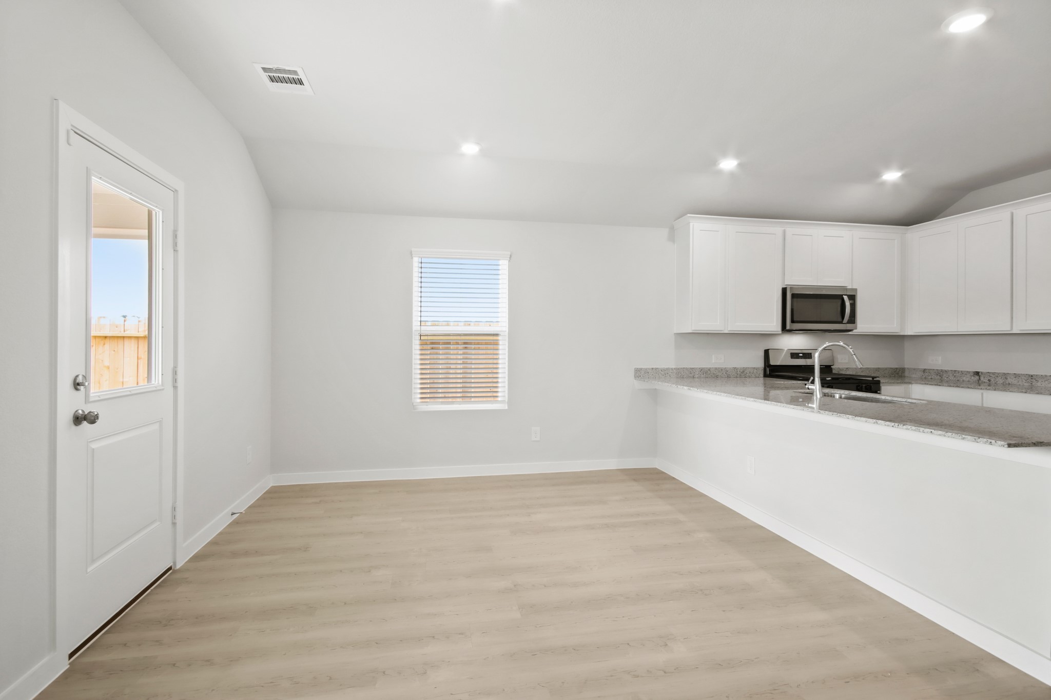 9715 Caney Bend Road Conroe, TX 77303 - Photo 5 of 24 a large white kitchen with wooden floor and black stainless steel appliances