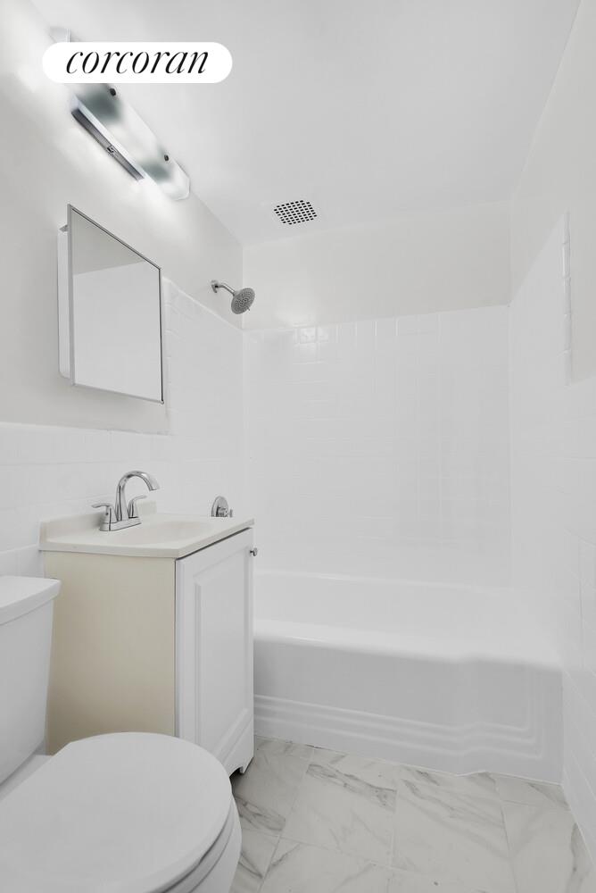 2830 Briggs Avenue, Unit WIA Bronx, NY 10458 - Photo 6 of 7 a bathroom with a sink a toilet and mirror