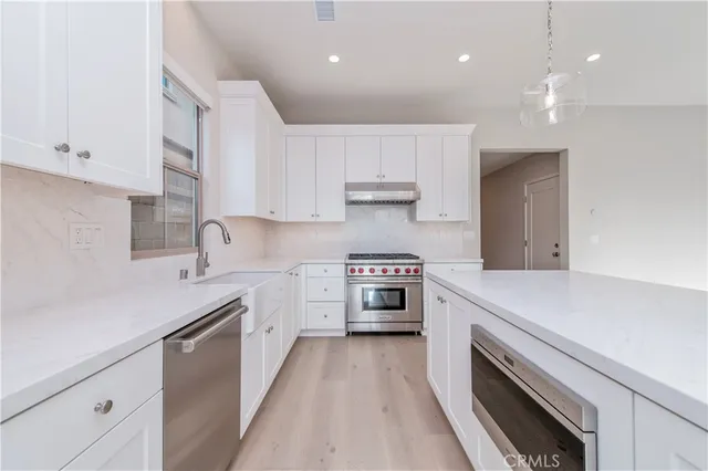 a kitchen with a sink stove top oven and cabinets
