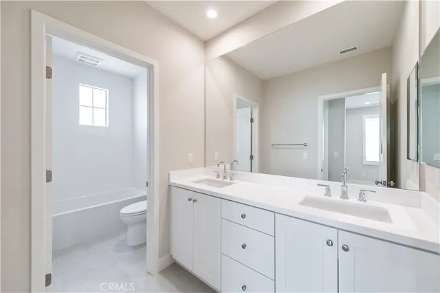 a bathroom with a toilet a sink a mirror a bathtub and shower