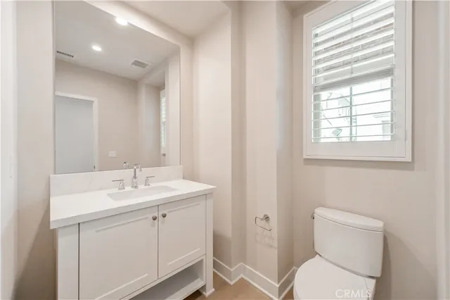 a view of bathroom with a toilet sink and mirror