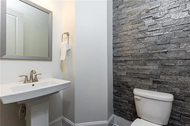 a bathroom with a toilet a sink and mirror