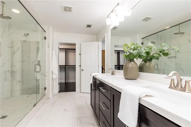 a bathroom with a granite countertop sink a shower and a mirror