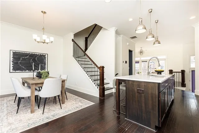 a dining room with wooden floor a chandelier a wooden table and chairs