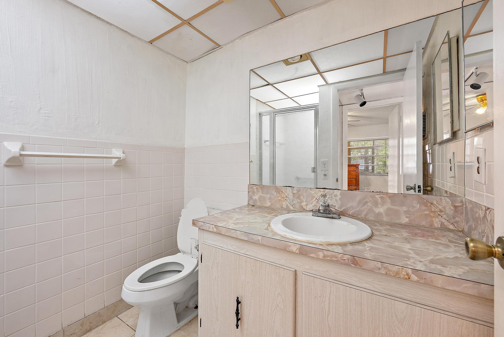 869 Flanders South Delray Beach, FL 33484 - Photo 9 of 13 a bathroom with a sink toilet and shower