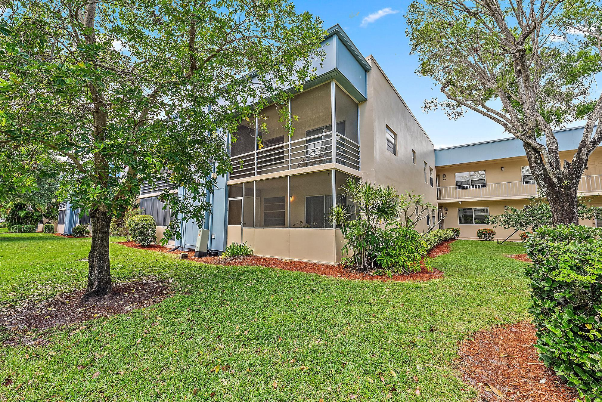 869 Flanders South Delray Beach, FL 33484 - Photo 10 of 13 a front view of a house with a yard and trees