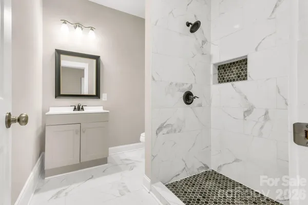 a bathroom with a sink a toilet and shower