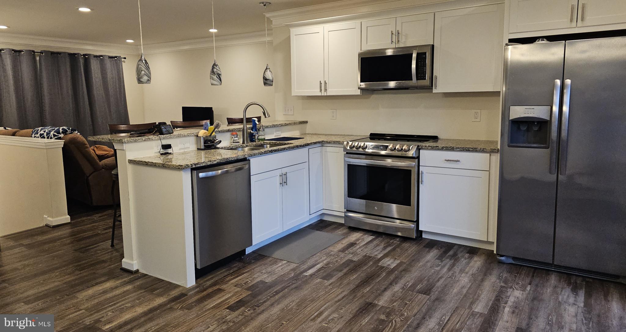 809 Duvall Highway Pasadena, MD 21122 - Photo 12 of 38 a kitchen with stainless steel appliances kitchen island hardwood floor sink and stove