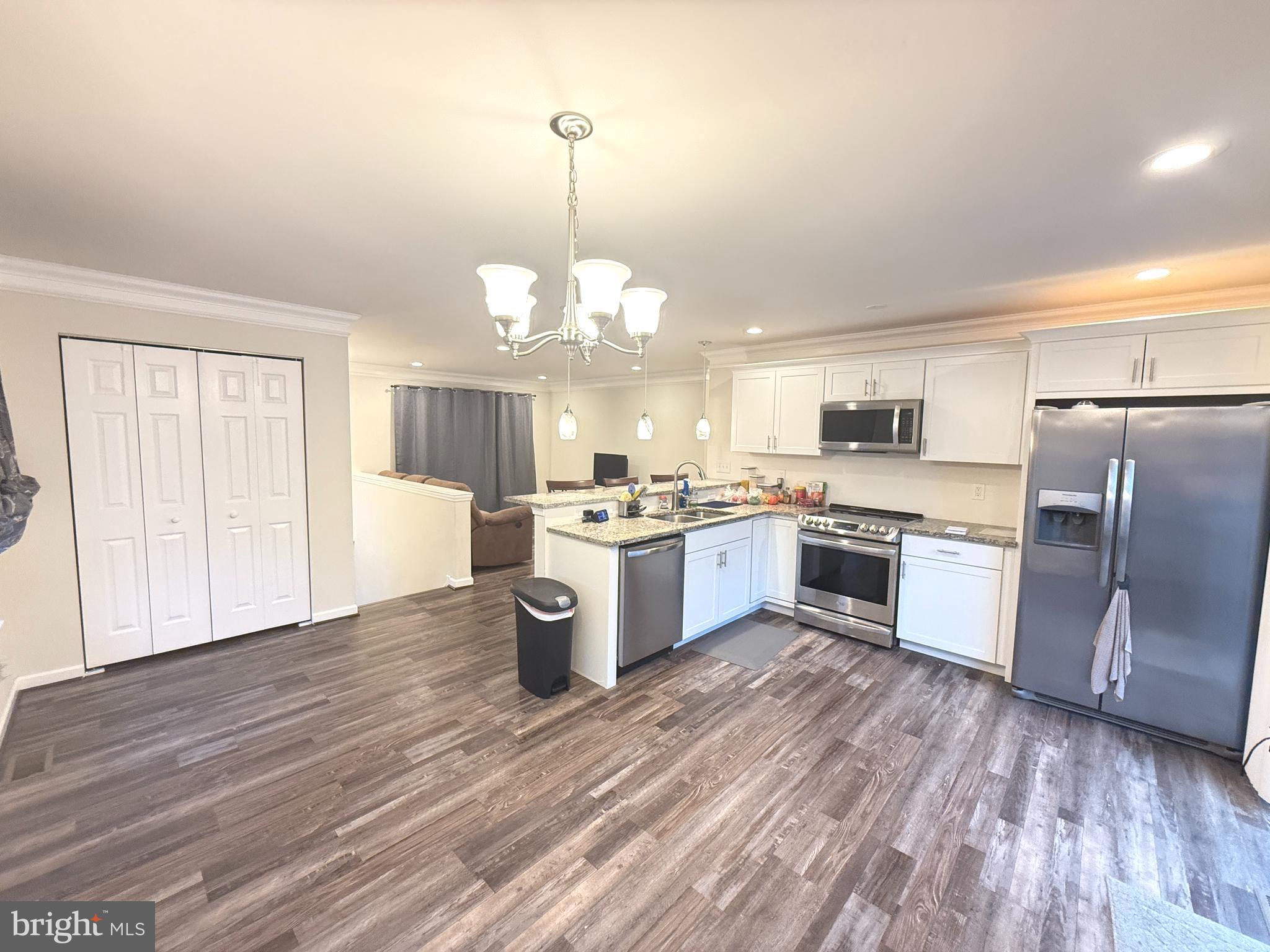 809 Duvall Highway Pasadena, MD 21122 - Photo 3 of 38 a large kitchen with a center island stainless steel appliances wooden floor and window