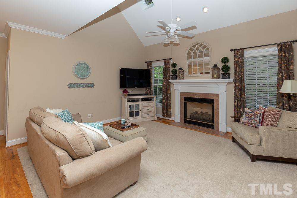 5004 Martin Farm Road Raleigh, NC 27613 - Photo 13 of 25 a living room with furniture a flat screen tv and a fireplace