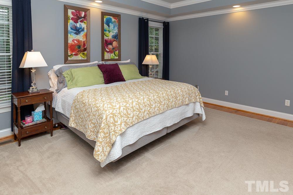 5004 Martin Farm Road Raleigh, NC 27613 - Photo 15 of 25 a bed sitting in a bedroom next to a painting on the wall
