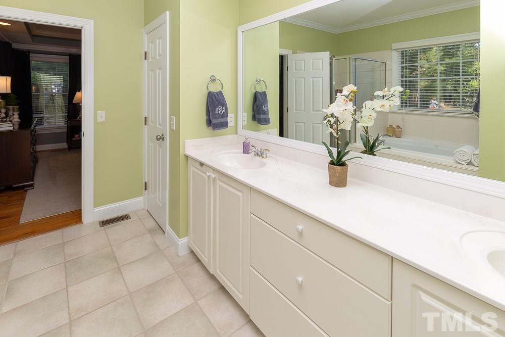 5004 Martin Farm Road Raleigh, NC 27613 - Photo 16 of 25 a bathroom with a sink a mirror and a bathtub