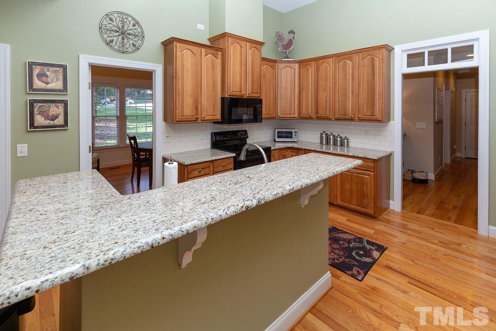 5004 Martin Farm Road Raleigh, NC 27613 - Photo 6 of 25 a kitchen with stainless steel appliances granite countertop a sink a stove and a refrigerator