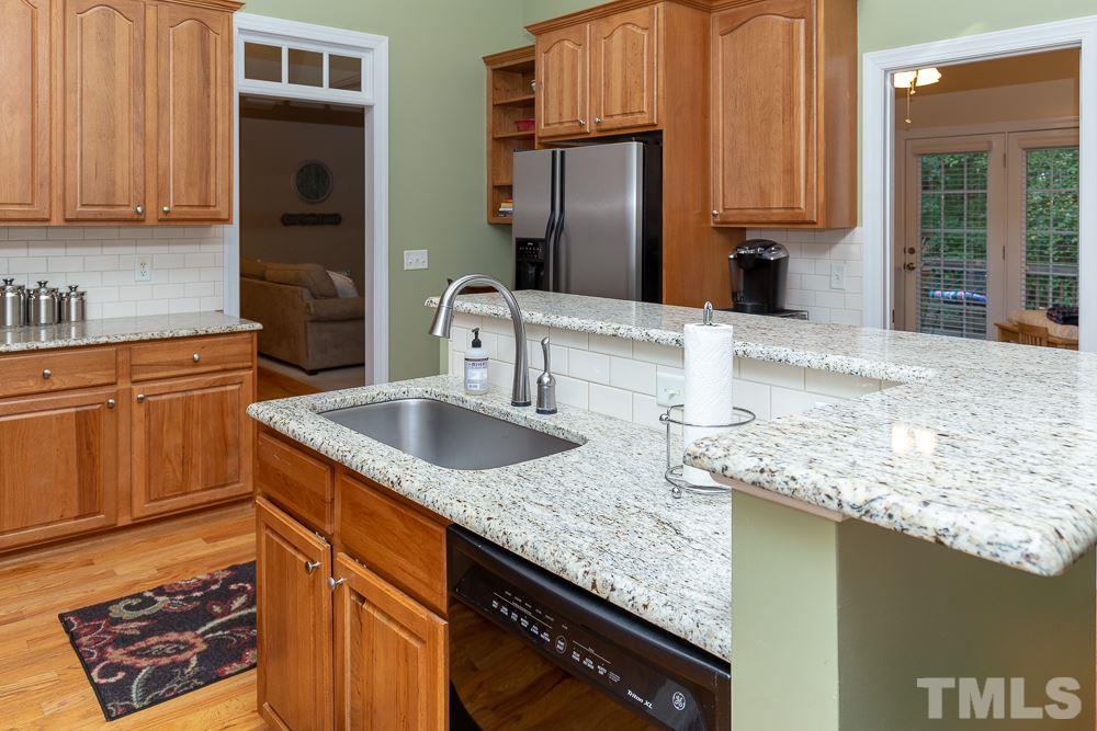 5004 Martin Farm Road Raleigh, NC 27613 - Photo 7 of 25 a kitchen with granite countertop a sink a stove and cabinets