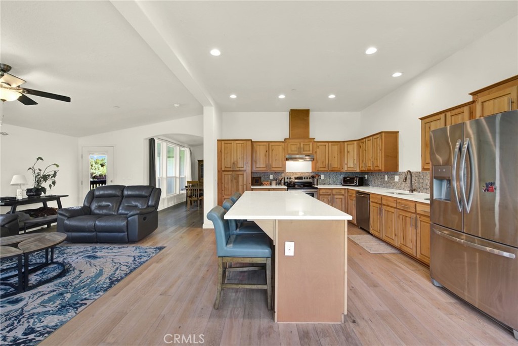 23580 Loleta Avenue Corning, CA 96021 - Photo 30 of 70 a kitchen with a refrigerator a stove top oven a sink dishwasher and white cabinets with wooden floor