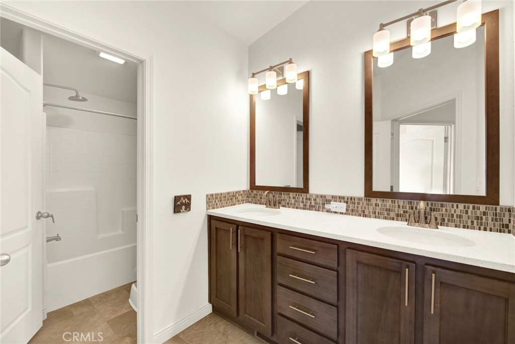 23580 Loleta Avenue Corning, CA 96021 - Photo 44 of 70 a bathroom with a double vanity sink a mirror a bathtub and shower