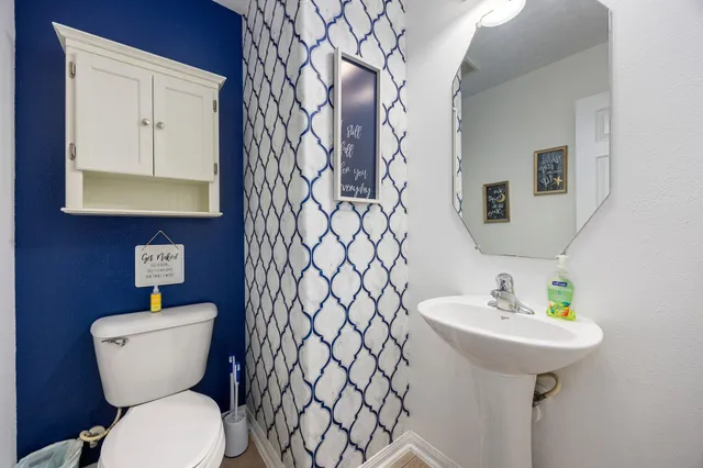 a bathroom with a toilet sink and mirror