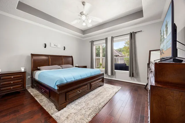 a bedroom with a bed dresser and a large window