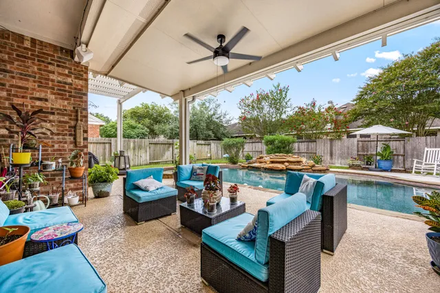 a living room with patio furniture and a potted plant