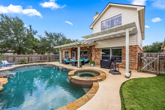 a view of a house with swimming pool and sitting area