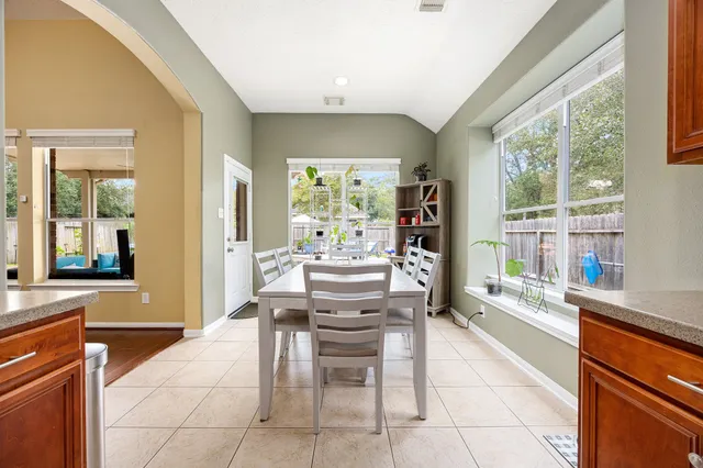 a dining room with furniture and a large window
